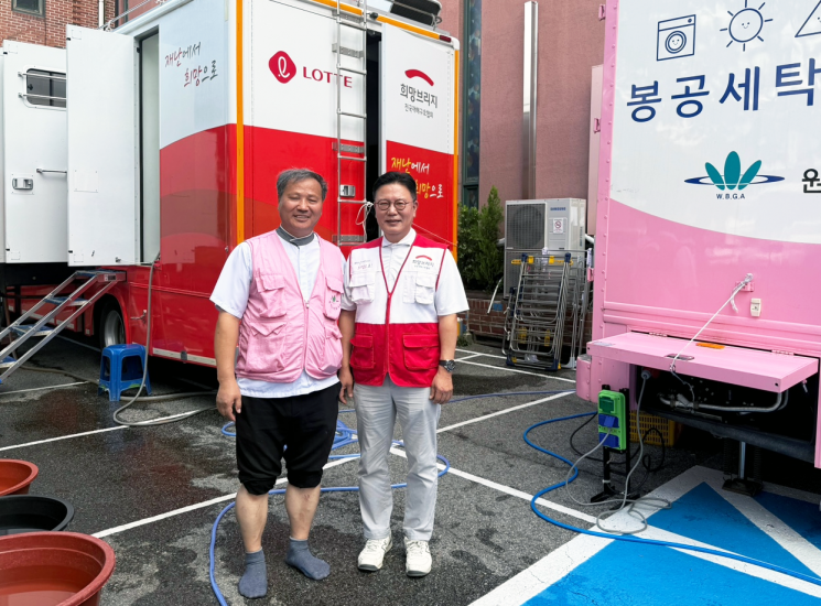 서울 은평구 세탁구호활동 현장을 찾은 희망브리지 신훈 사무총장이 원불교 봉공회 강명권 교무와 기념사진 촬영을 하고 있다. 희망브리지