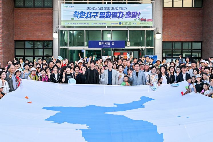 22일 5·18과 8·15를 잇는 ‘착한서구 평화열차’ 첫 운행에 앞서 참가자 328명이 대형 한반도기에 평화의 염원을 담은 종이 비행기를 날린 후 기념촬영을 하고 있다. 광주 서구 제공