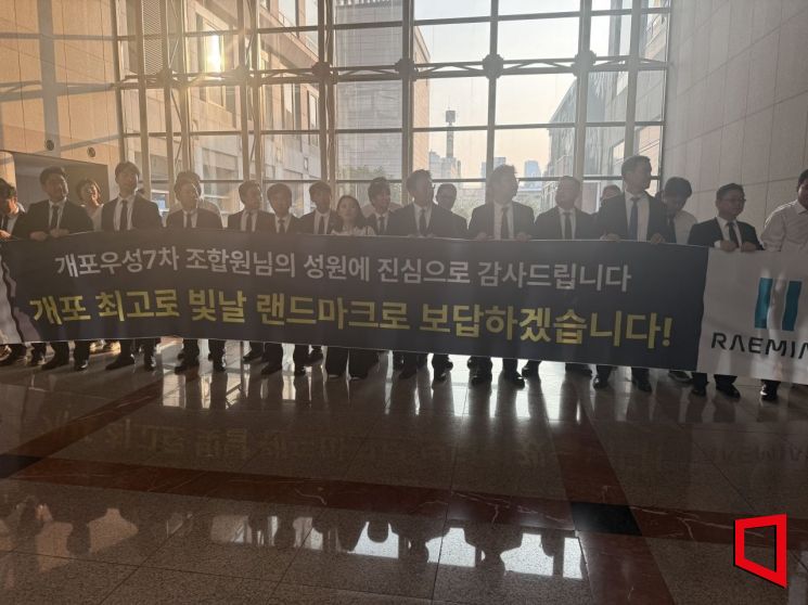 지난 23일 개포우성7차 재건축 조합이 개최한 시공사 선정 총회에서 68표 차로 삼성물산이 대우건설을 누르고 시공사로 선정됐다. 선정 직후 임직원들이 현수막을 들고 조합원들에게 인사하고 있다. 한진주 기자