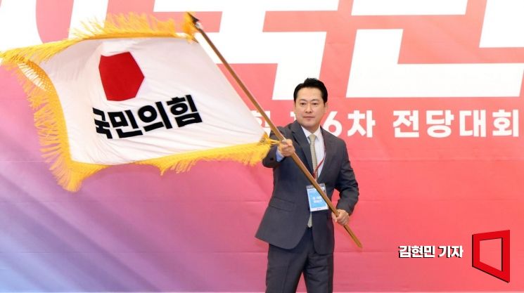 장동혁 국민의힘 신임 당대표가 26일 국회 도서관에서 열린 제6차 전당대회 결선에서 당기를 흔들고 있다. 국회사진기자단