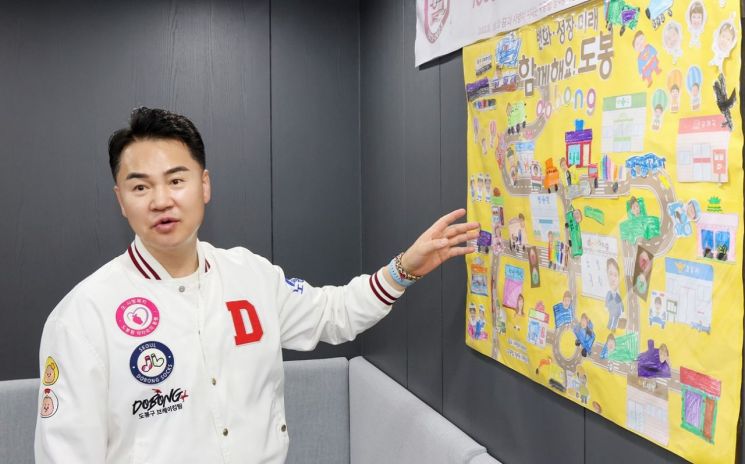 오언석 도봉구청장이 구청장실 입구에 걸려 있는 그림판에 대해 설명하고 있다. 그림판에는 창4동 어린이집 원생들의 손글씨와 감사 인사가 적혀 있다. 도봉구 제공.