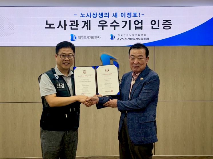 정명섭 대구도시개발공사 사장(오른쪽)과 천상필 노조위원장이 노사관계우수기업 인증서를 들고 기념촬영을 하고 있다.