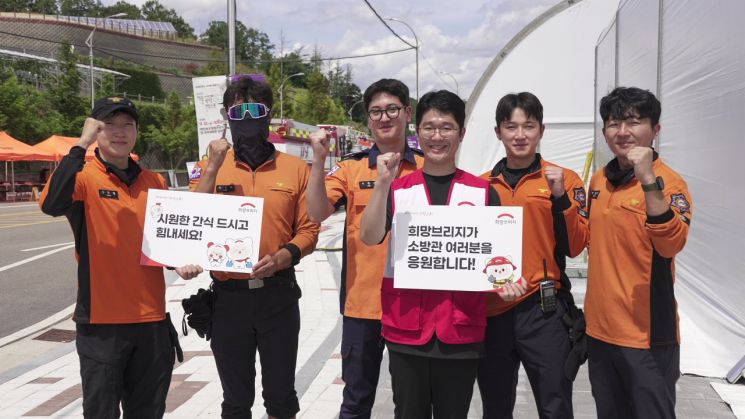 전국재해구호협회 직원이 긴급구호종합훈련에 참여한 소방대원들에게 간식을 지원한 뒤 기념촬영을 하고 있다. 전국재해구호협회