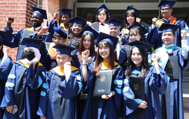 지난달 21일 부산 서구 동아대학교 부민캠퍼스에서 열린 2024학년도 후기 외국인 유학생 졸업환송회에서 식을 마친 외국인 유학생들이 석당박물관 앞에서 기념사진을 찍고 있다. 연합뉴스
