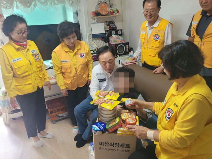 김철수 대한적십자사 회장이 가뭄으로 고통받는 강릉지역 취약계층 가정에 방문하여 물품들을 전달하고 있다. 대한적십자사