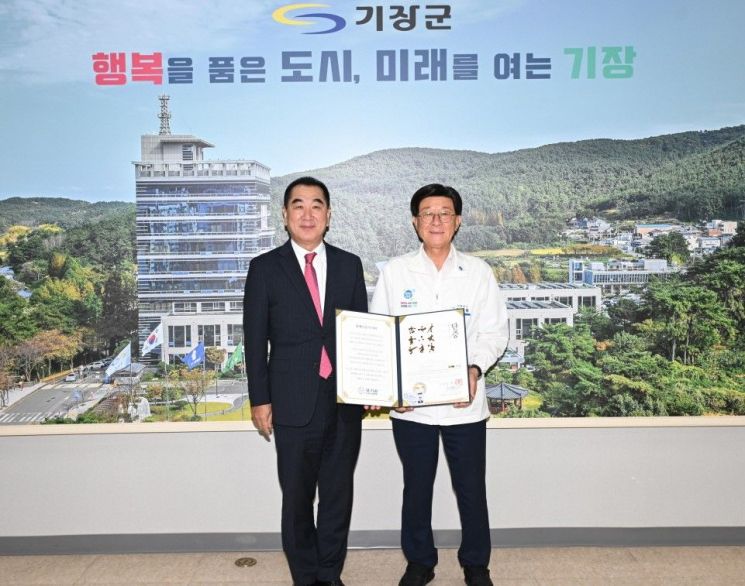 정종복 기장군수가 최재춘 위원장(좌측)으로부터 명예 단증을 받고 있다. 기장군 제공