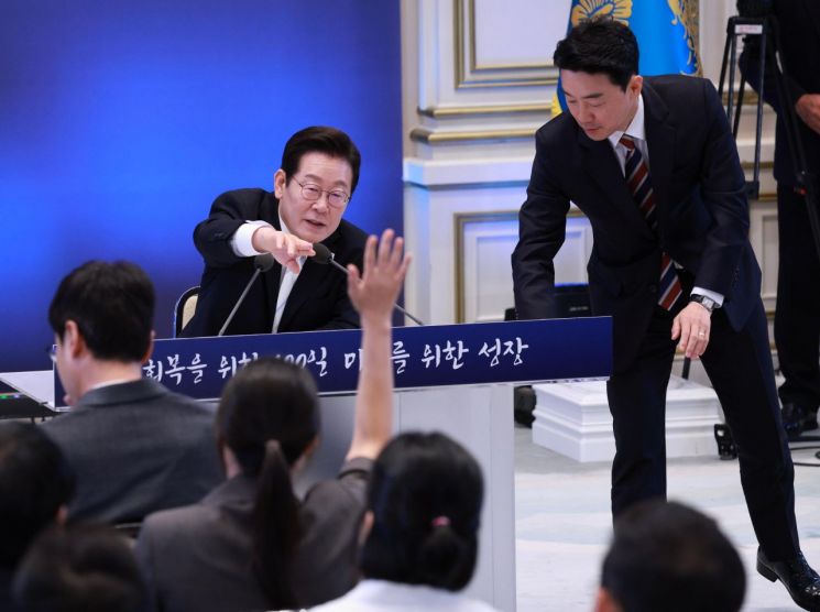 11일 청와대 영빈관에서 이재명 대통령 취임 100일 기자회견을 하던 중 이 대통령 책상 앞 판이 기울어지자 강훈식 비서실장이 정리하고 있다. 연합뉴스