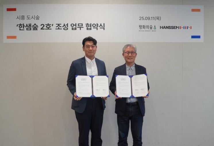 한샘은 경기 시흥시 시화공업단지 인근에 ‘한샘숲 2호’를 조성하기 위해 평화의숲과 업무협약(MOU)을 체결했다. 정광현 한샘 경영지원본부장(왼쪽)과 김재현 평화의숲 대표가 기념 사진을 촬영하고 있다. 한샘