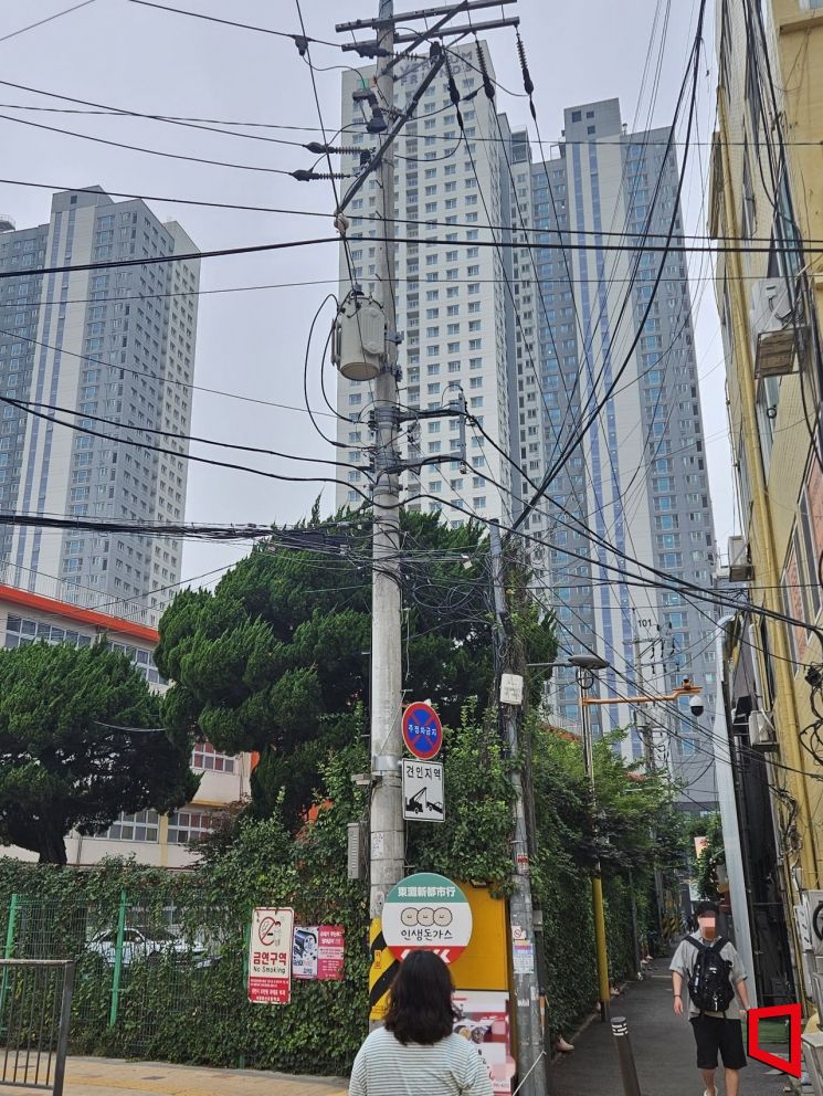 On the 13th, electric wires and communication lines are tangled on a utility pole near Yongsan Elementary School in Seoul. Photo by Seungwook Park