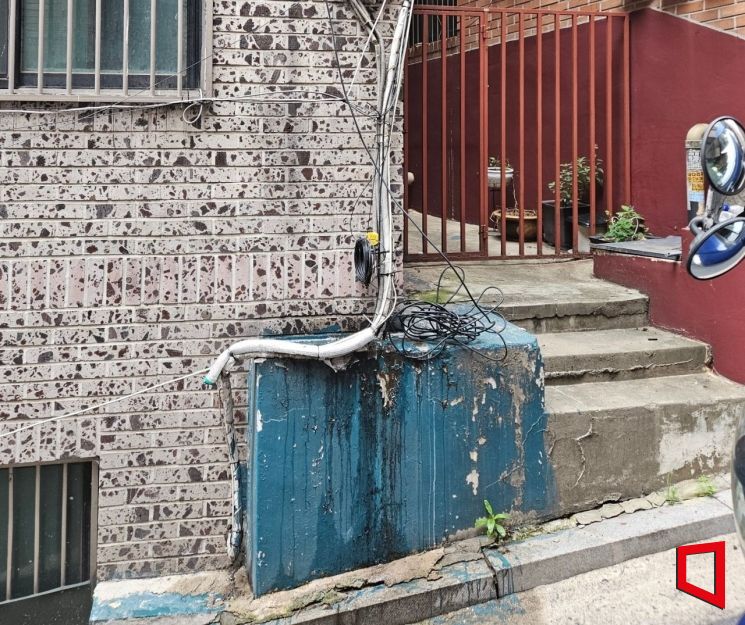 On the 13th, communication lines have descended to the ground at a villa in Jangchung-dong, Jung-gu, Seoul. Photo by Park Seungwook