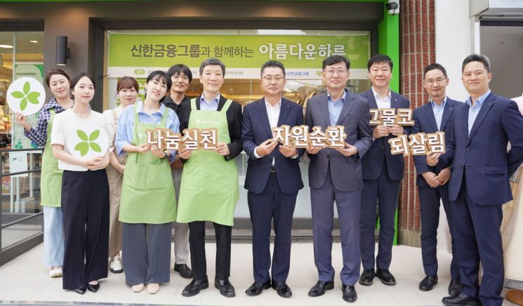 김재민 신한은행 부행장(왼쪽에서 일곱번째)이 지난 12일 서울 종로구 아름다운가게 안국점을 찾아 임직원 기부물품을 전달하고 박진원 아름다운가게 이사장 및 관계자들과 기념 촬영을 하고 있다. 신한금융 제공