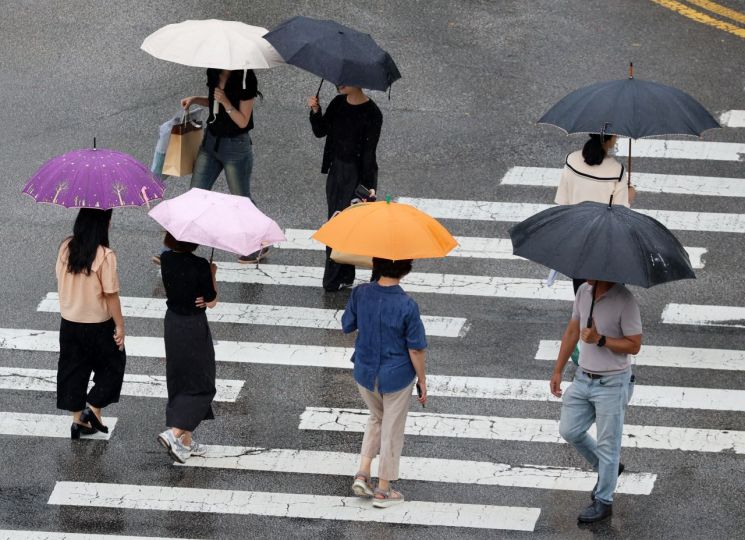 15일 광주 북구청 사거리에서 시민들이 내리는 비에 우산을 쓰고 걷고 있다. 연합뉴스