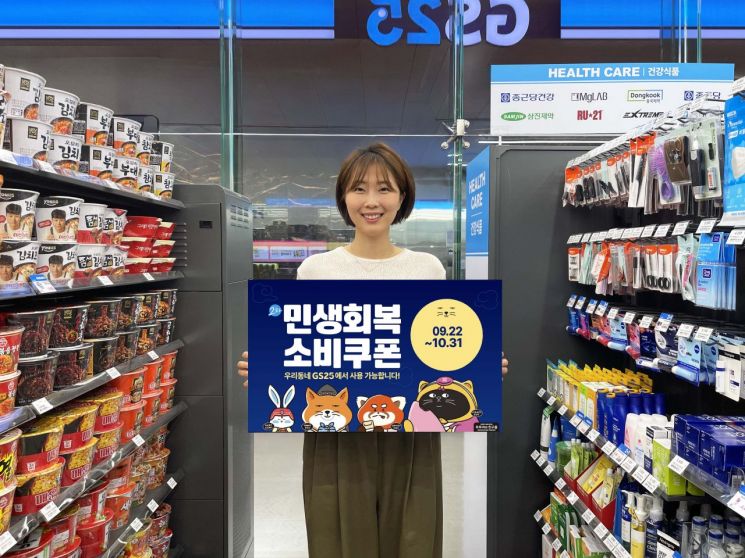 GS25에서 모델이 민생회복 소비쿠폰 홍보물을 들고 있다. GS리테일 제공