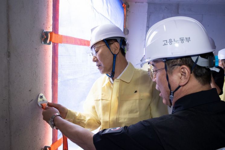 김윤덕 국토부 장관(왼쪽)과 김영훈 노동부 장관이 18일 서울 용산구 청년주택 신축 공사 현장에서 추락 방지를 위한 안전 고리를 점검하고 있다. 국토부·노동부
