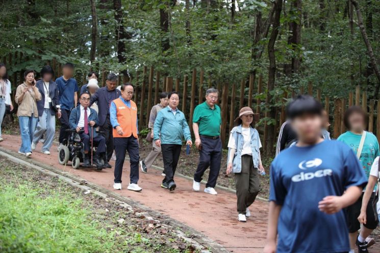 주광덕 남양주시장이 18일 광릉숲 일대에서 장애인과 비장애인이 함께 걷고 공감하는 '마음이 걷는 슬로우 트래킹' 대회에 참석해 참석자들과 함께  걷고 있다. 남양주시 제공