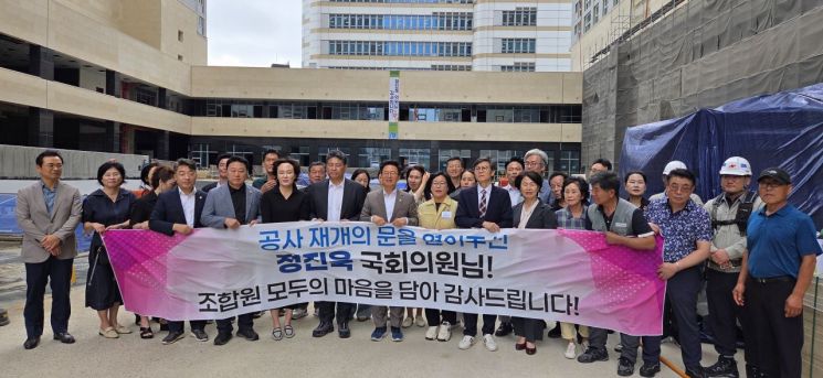 19일 오후 광주 남구 봉선동 주월동지역주택조합 주상복합 신축 공사장에서 열린 공사 재개 기념식에서 조합원들이 기념사진을 촬영하고 있다. 민찬기 기자
