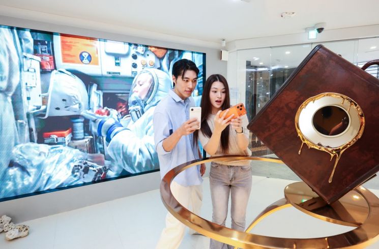 LG유플러스 모델이 서울 강남구 복합문화공간 '일상비일상의틈'에서 아이폰17 시리즈 팝업 전시를 소개하고 있다. LG유플러스 제공