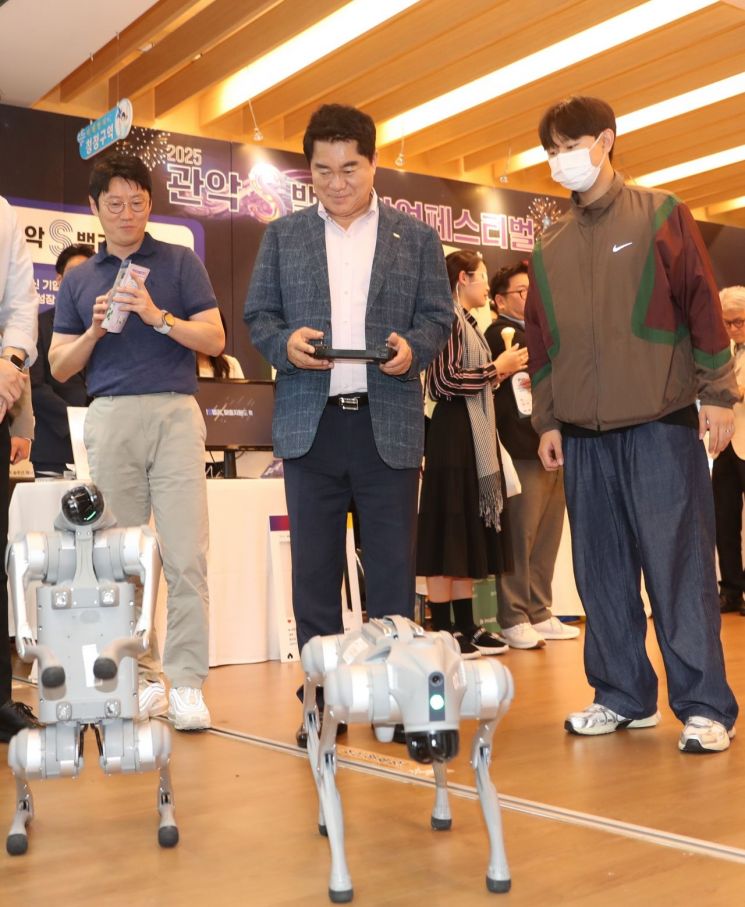 박준희 관악구청장(가운데)이 19일  ‘2005 관악S밸리 창업페스티벌' 홍보·체험존에서 로봇을 작동하고 있다. 관악구 제공.