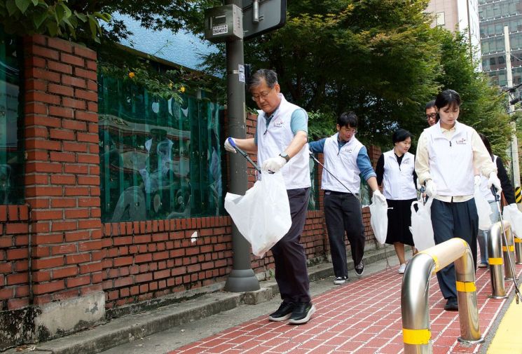 정선용 한국지방재정공제회 이사장과 재정공제회 직원들이 지난 19일 서울 마포 초등학교 앞 보행로에서 환경정화 활동을 펼치고 있다. 한국지방재정공제회 제공