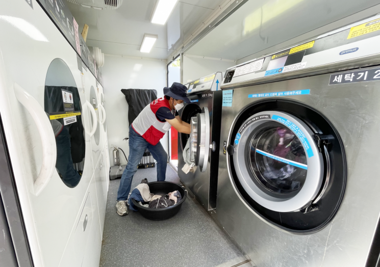 희망브리지 자원봉사자가 이동식 세탁구호차량 내부에서 수거한 세탁물을 세탁하고 있다. 희망브리지