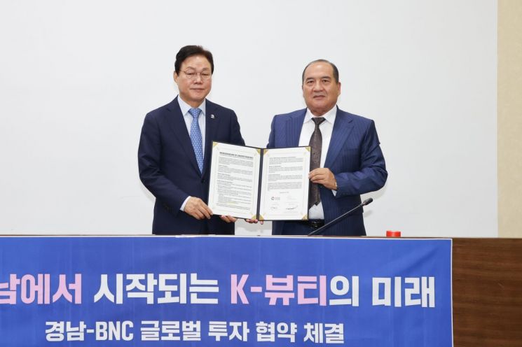 박완수 경남도지사(왼쪽)와 보저로브 래크맛 호미도비치(Bozorov Lakhmat Khomidovich) 비엔씨 글로벌 회장이 서명한 업무협약서를 함께 들어보이고 있다. 경남도 제공