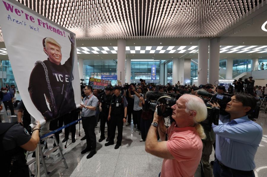 미국 이민당국에 의해 조지아주에 구금됐던 한국인 근로자들이 귀국한 12일 인천국제공항 제2여객터미널 입국장에서 도널드 트럼프 미국대통령 얼굴 배너를 든 시민단체가 시위하고 있다. 2025.9.12  연합뉴스