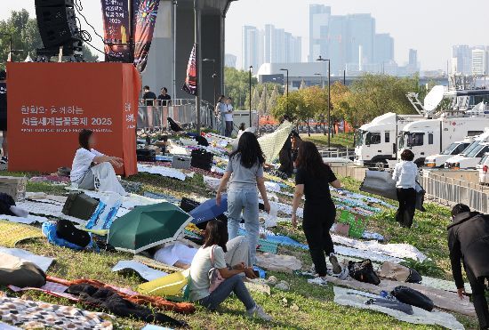 '서울세계불꽃축제 2025'를 하루 앞둔 26일 행사장 주변에서 시민들이 돗자리를 펴고 자리를 선점하고 있다.＜저작권자(c) 연합뉴스, 무단 전재-재배포, AI 학습 및 활용 금지＞