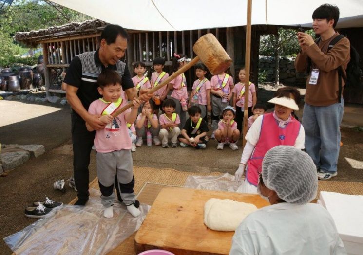 서산 해미읍성축제 떡메치기 체험에 참가한 아이들이 직접 장인과 함께 떡을 메치는 모습. 서산문화재단 제공