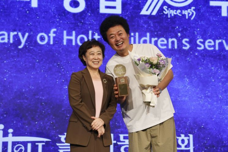감사패를 수상한 윤택 홍보대사가 신미숙 홀트아동복지회장과 기념촬영을 하고 있다. 홀트아동복지회