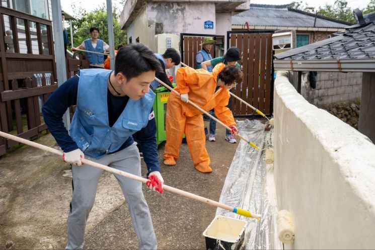 광양제철소 봉사단원들이 벽화를 위한 밑도색 작업을 진행하고 있다. 광양제철소 제공