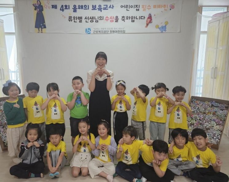 제4회 올해의 보육교사로 선정된 근로복지공단 창원어린이집 류한별 교사가 시상식 후 원생들과 함께 카메라 앞에 섰다.