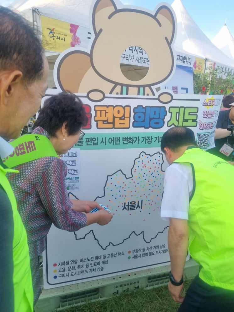 구리가 서울 되는 범시민 추진위원회가 지난 26일부터 28일까지 구리 한강시민공원에서 열린 구리 코스모스 축제 현장에서 구리시의 서울 편입을 위한 스티커를 붙이기 행사를 진행하고 있다. 구리시 제공