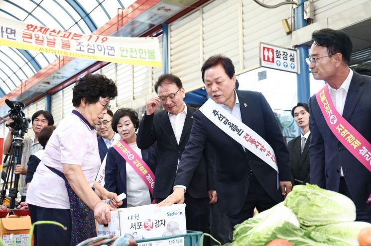 박완수 경남도지사가 사천시 사천읍시장에서 햇감자를 살펴보며 시장 상인과 대화하고 있다. 경남도 제공