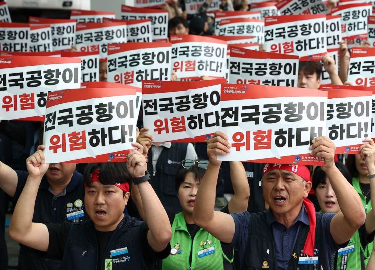 인천국제공항 노동자가 가입한 민주노총 공공운수노조 인천공항지역지부와 나머지 14개 공항 노동자가 가입한 전국공항노동조합으로 구성된 전국공항노동자연대가  9월 19일 인천 영종도 인천국제공항 제2여객터미널에서 연 총파업 대회에서 참가자들이 손팻말을 들고 구호를 외치고 있다. 2025.9.19 연합뉴스