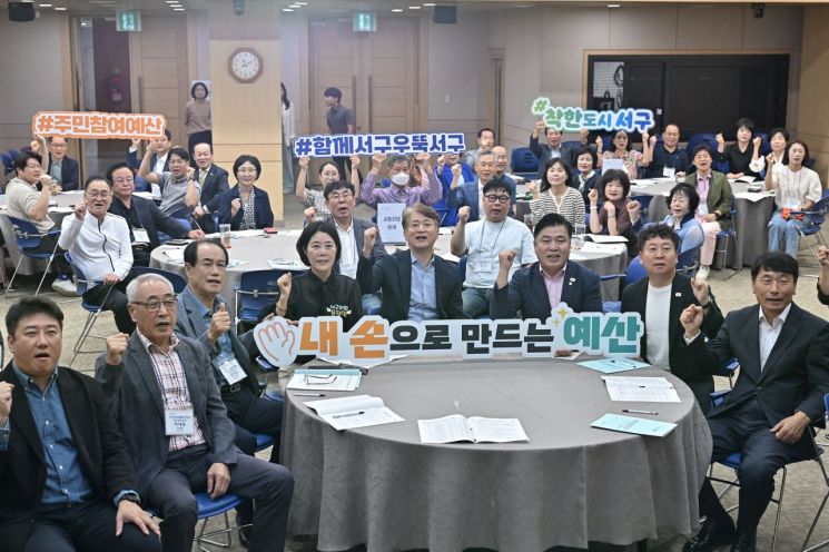 김이강 광주 서구청장이 지난달 30일 서구청 들불홀에서 열린 '주민참여예산위원회 회의'에서 참석자들과 기념촬영을 하고 있다. 광주 서구 제공