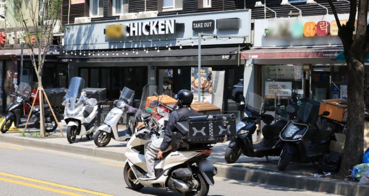 서울 시내 한 음식점 앞으로 배달 라이더가 지나고 있다. 연합뉴스
