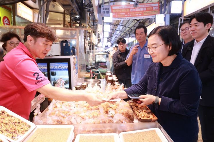 한성숙 중소벤처기업부 장관이 1일 서울 서대문구 독립문 영천시장을 방문해 물건을 구입하고 상인들을 격려하고 있다. 중소벤처기업부