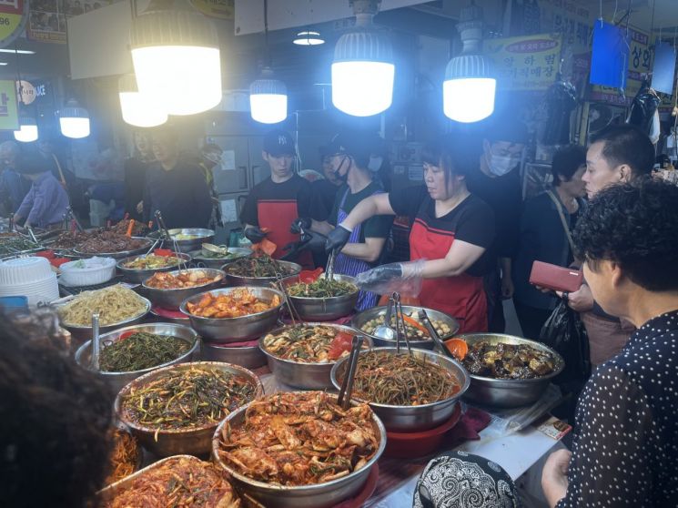 각종 반찬을 담느라 손놀림이 분주한 반찬가게. 송보현 기자