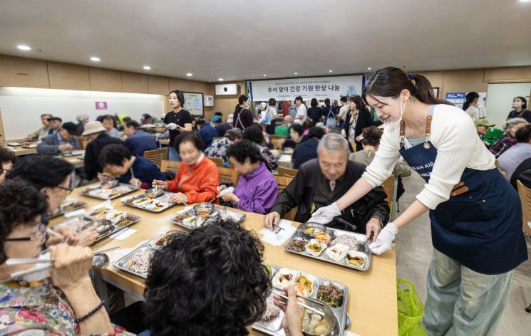 대한항공-아시아나항공 양사 임직원들이 서울 강서구 지역 어르신들에게 추석 음식을 대접하고 있다. 대한항공 제공
