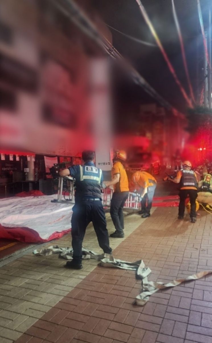 7일 오전 1시 23분께 영도구 동삼동 4층 건물의 2층 노래연습장에서 불이 나자 경찰과 소방이 진화 및 구조작업을 벌이고 있다. 부산경찰청.