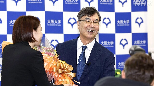 사카구치 시몬 오사카대 명예 교수가 노벨상 수상을 축하하는 꽃다발을 받고 있다. NHK.
