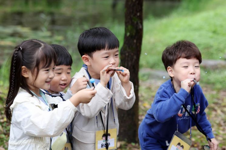 14일 오전 광주 북구 충효동 호수생태원에서 열린 '기후 위기와 저탄소 친환경 실천을 위한 유아 기후생태 놀이교실' 참가 어린이들이 나뭇가지를 이용해 식물의 영양분 섭취 원리를 배우고 있다.  광주 북구 제공, 연합뉴스