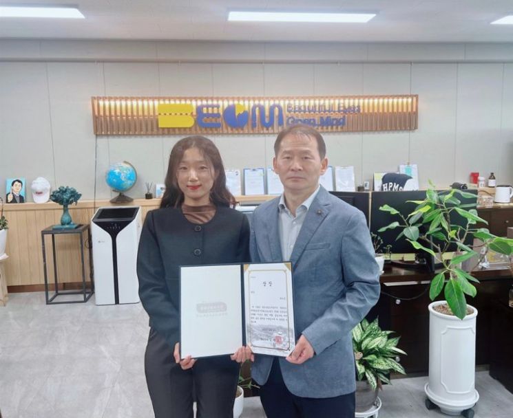 대구 현풍중학교에 근무하는 차가은(왼쪽)씨가  께 학교 이정열 교장과 함께 최우수상 상을 들어보이고 있다.