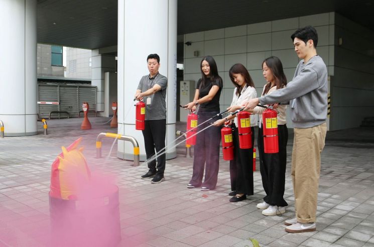 에어부산 사옥에서 진행된 산업재해 비상대응 훈련에 임직원들이 참여하여 소화기 사용법 밎 진화 교육을 받고 있다.