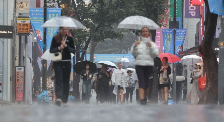 서울 중구 명동거리에서 시민 및 외국인관광객들이 우산을 쓴 채 걸어가고 있다. 연합뉴스