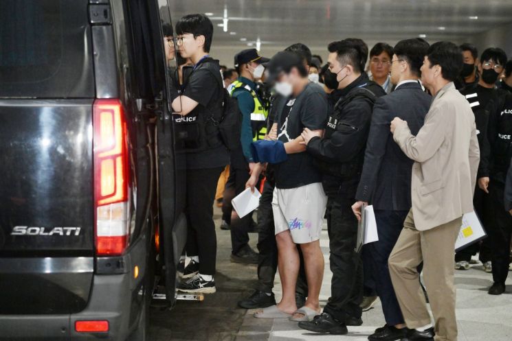 캄보디아 온라인 사기에 가담해 구금된 한국인들이 18일 오전 인천국제공항 제2터미널을 통해 송환돼 호송차에 오르고 있다. 연합뉴스