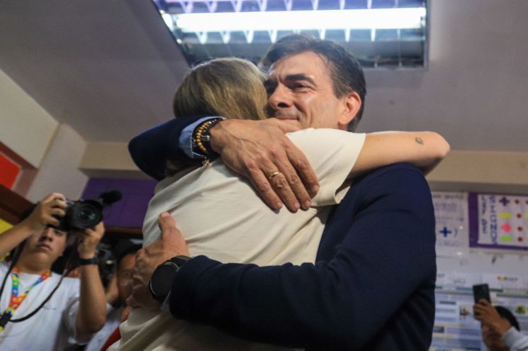 로드리고 파스 대통령 당선인이 19일(현지시간) 볼리비아 라파스의 한 투표소에서 한 지지자와 포옹하고 있다. EPA연합뉴스