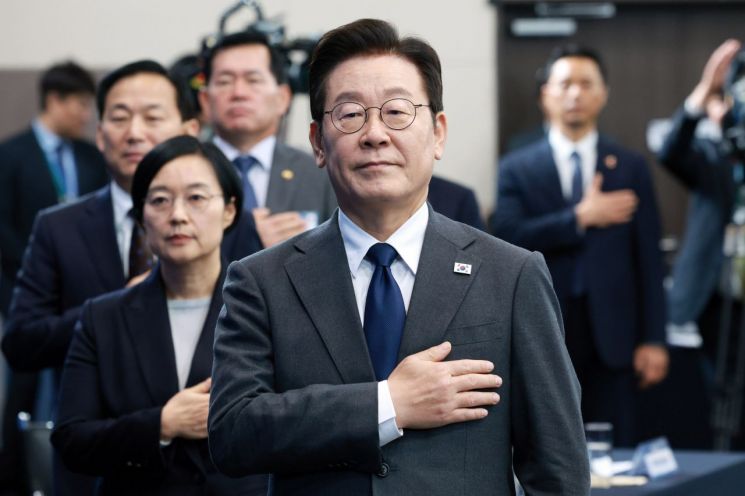 이재명 대통령이 20일 경기도 고양시 킨텍스에서 열린 방위산업 발전 토론회에서 국기에 경례하고 있다. 연합뉴스