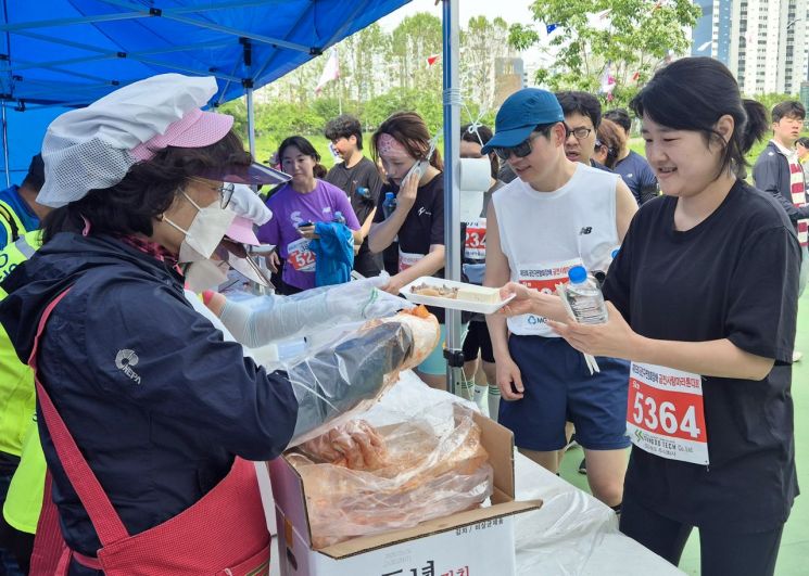 지난 5월 열린 금천구육상연맹회장배 금천사랑 마라톤대회에서참가자들이 수육과 김치를 받아가고 있다. 금천구 제공.