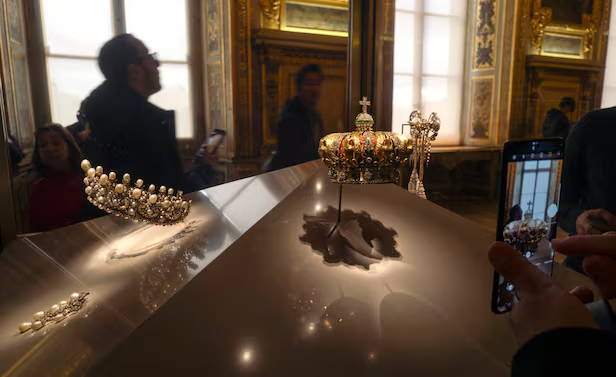 The Apollo Gallery (left), admired by tourists, and footage obtained and released by French broadcaster BFMTV show a man wearing fluorescent work clothes touching the security glass in the Louvre Apollo exhibition room while working. At first glance, it looks like a routine artifact inspection by museum staff, but this was a planned criminal act. /AFP Yonhap News, Youtube 'BFMTV'